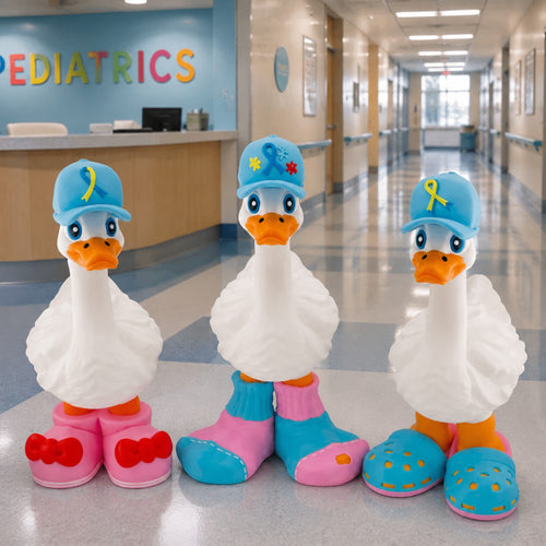 Prints & Giggles 3D awareness ribbon hats on three white goose figurines in a pediatric hospital hallway