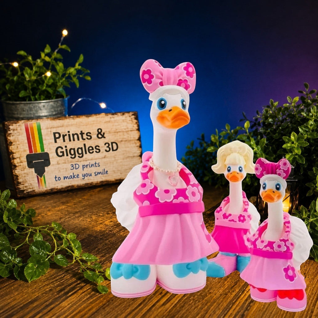 Prints & Giggles 3D decorative goose figurines wearing pink floral dresses and matching bows on a white background.
