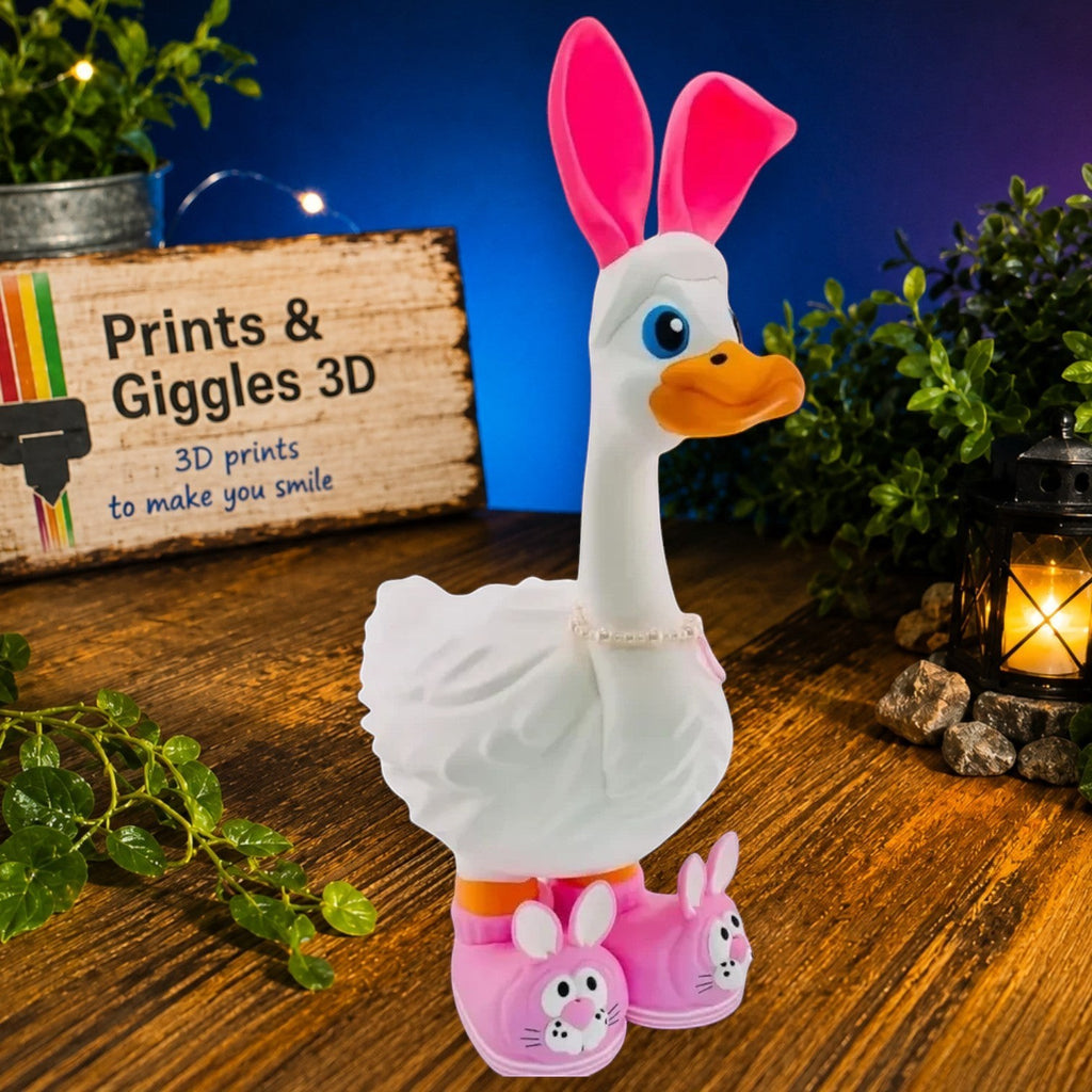 Prints & Giggles 3D white goose figurine wearing pink bunny ears, bunny slippers, and a delicate faux-pearl necklace.
