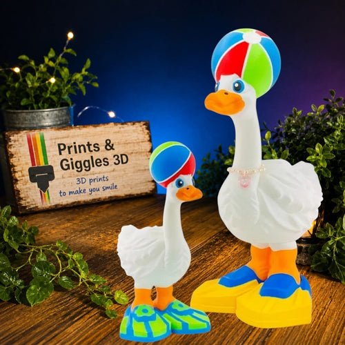 Prints & Giggles 3D white goose figurines wearing colorful beach ball hats, orange beaks, and pearl heart necklace.