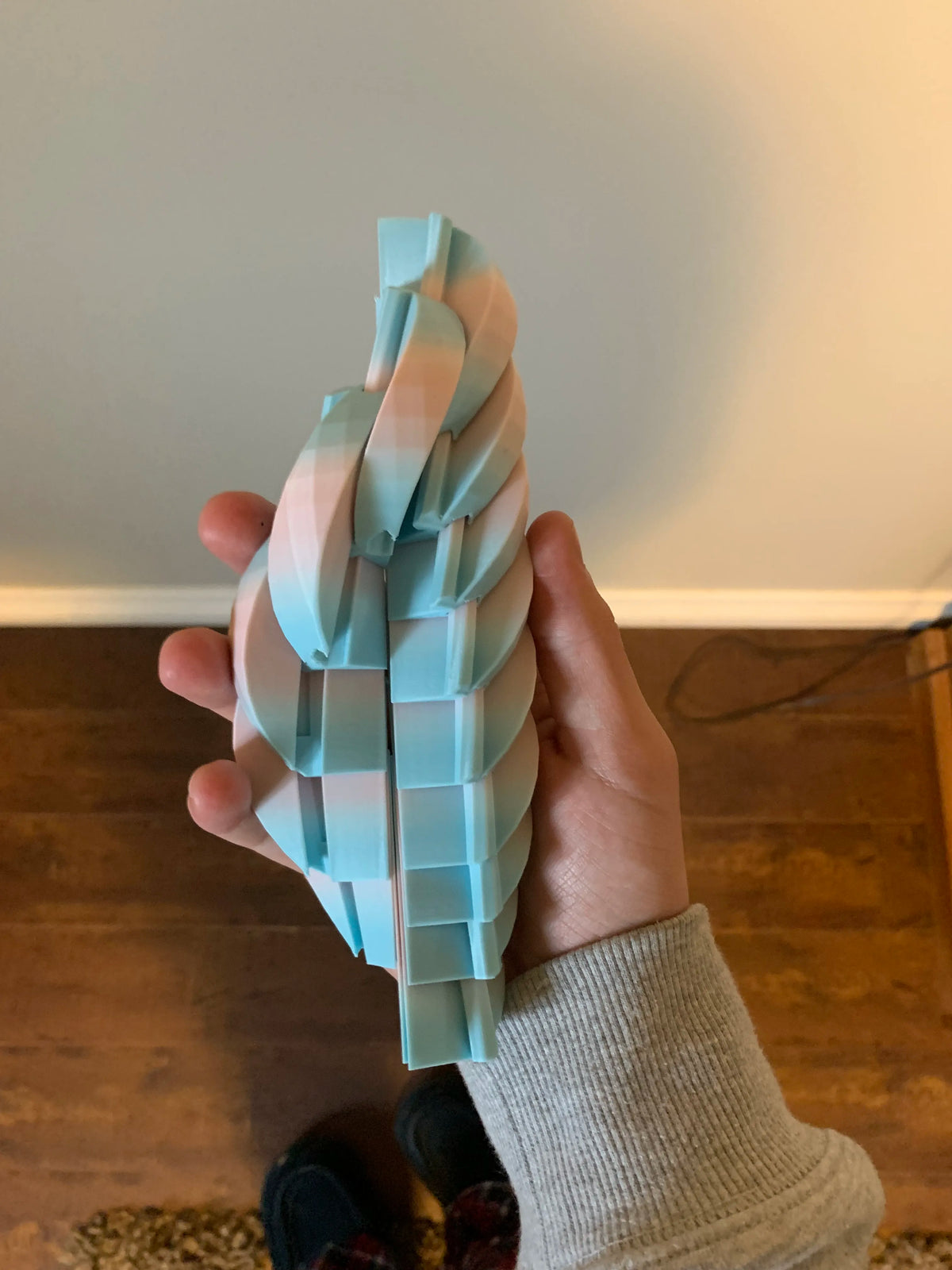 Twisty Fidget Ball opened and extended in a hand to show its movement